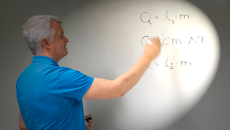 Lärare skriver ekvationer på whiteboard